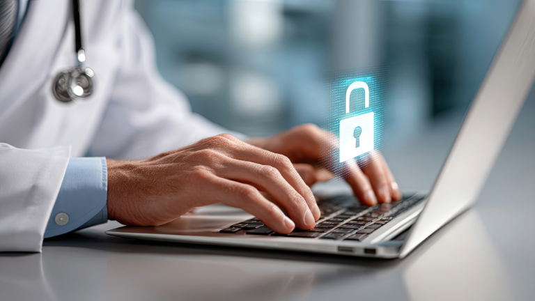 Healthcare worker typing on a laptop with a lock graphic at the center of the screen. 